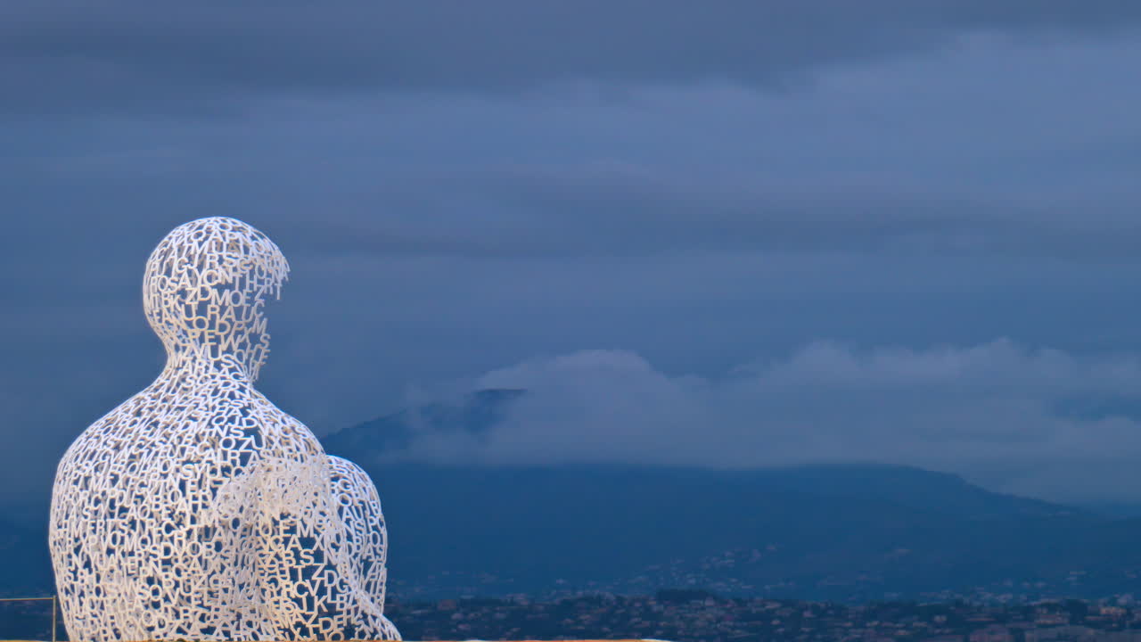 Distant view of The Nomad urban sculpture by Jaume Plensa in the evening in Antibes, France