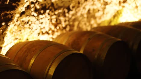 rows of barrels in a dimly lit cellar