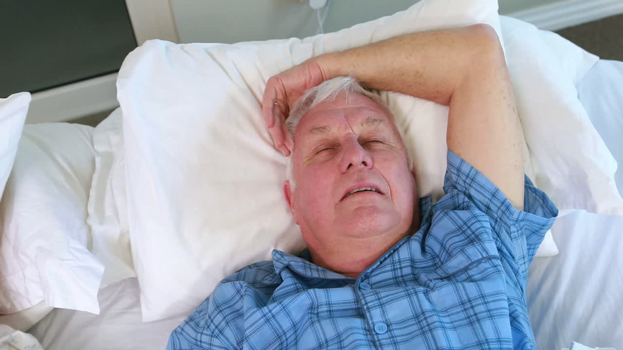 Senior woman blocking out his husband snoring