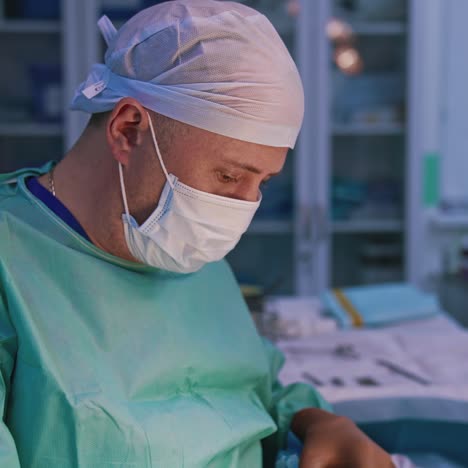 surgeon on the blur background of an operating room. portrait of a doctor in medical uniform conducting a plastic surgery. profile view