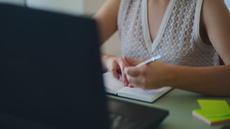 mujer tomando notas videoconferencia