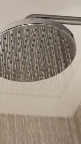 primer plano del cabezal de la ducha con agua corriente