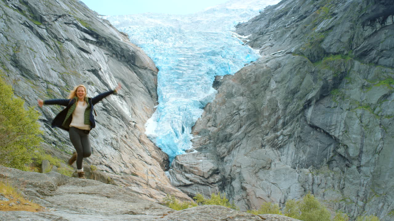 mujer feliz haciendo senderismo en las montañas glaciares de noruega