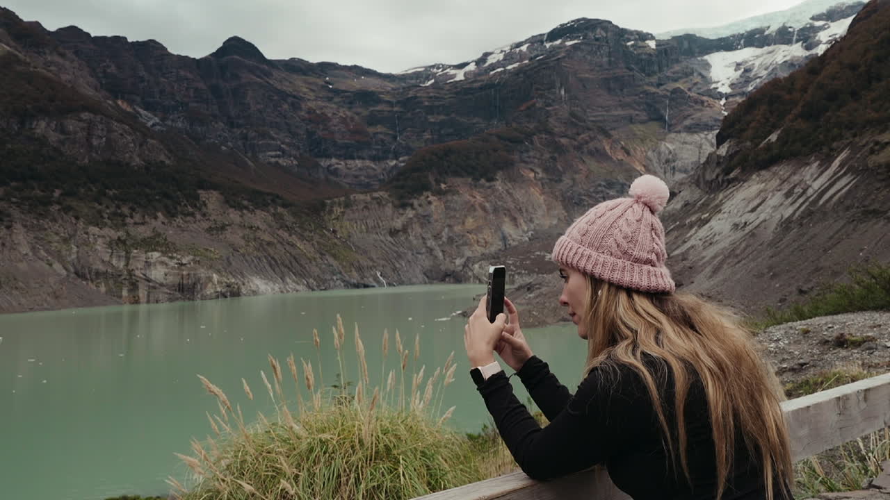 una mujer viajera toma fotos del derretimiento del glaciar ventisquero negro.