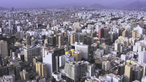 Impressive-drone-shot-of-the-Miraflores-district-in-the-city-of-Lima,-Peru-during-the-day-with-buildings-and-cars