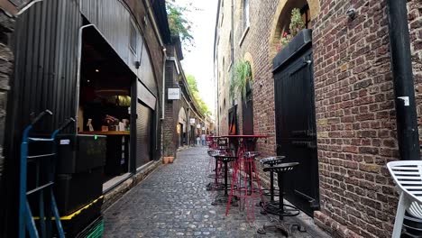 man sitting in alley with cafes