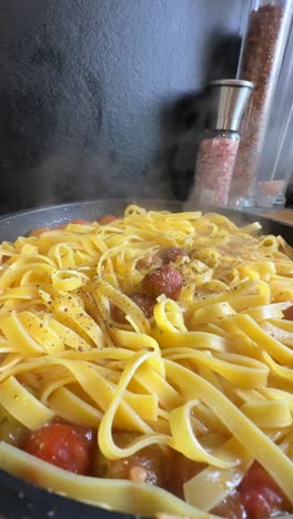 cooking tagliatelle with tomatoes and pepper