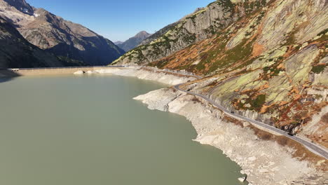 grimsel water reservoir and mountain pass road on a sunny day with scenic views from above