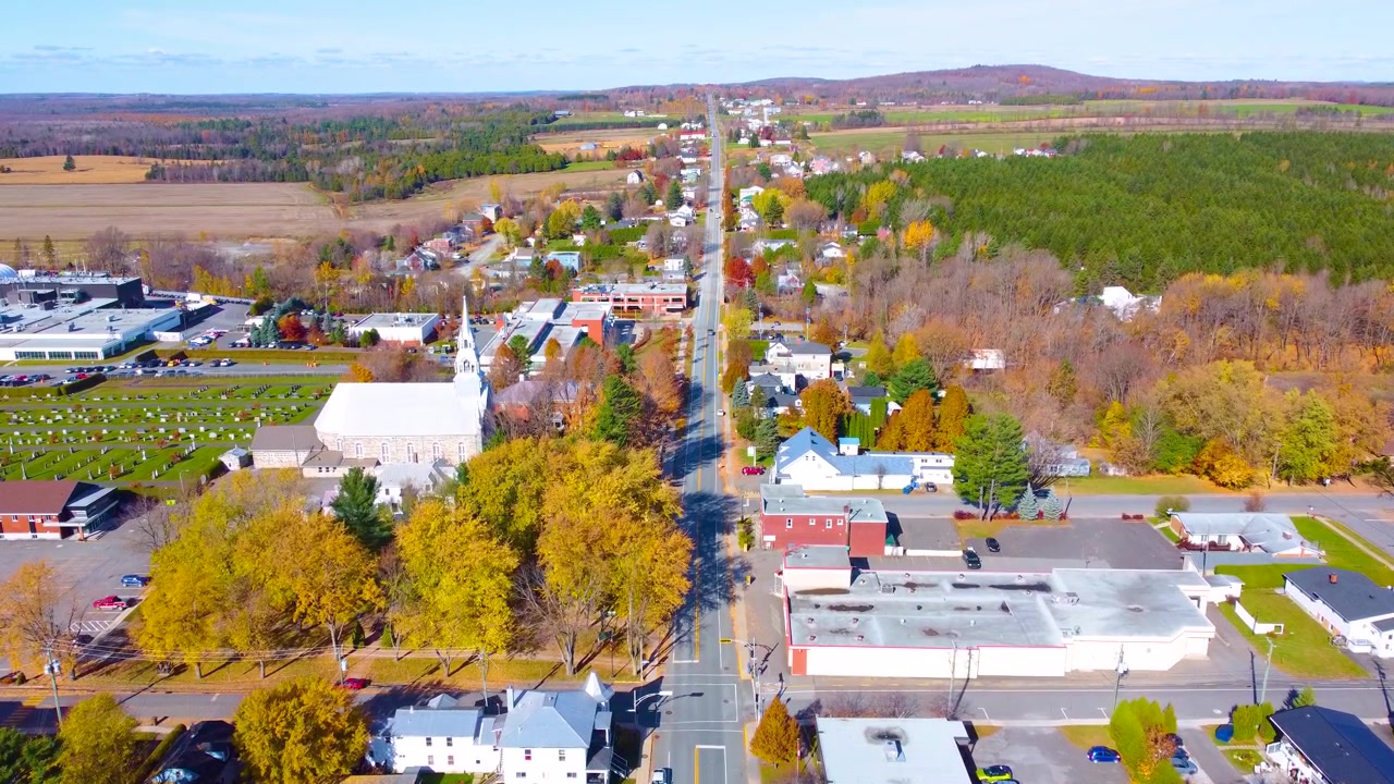 Pequena cidade em Estrie, Québec, capturada durante o outono com folhagem colorida e uma vista aérea nítida.