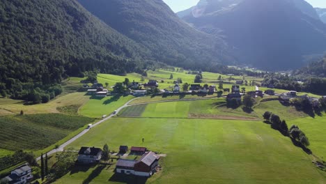 Campos-De-Cultivo-Verdes-En-Lodalen-Nordfjord-Noruega---Antena-En-Movimiento-Hacia-Adelante-Además-De-La-Carretera-Fv723-Y-Contra-La-Iglesia-De-Loen---Antena-De-Noruega-En-La-Hermosa-Luz-De-La-Mañana