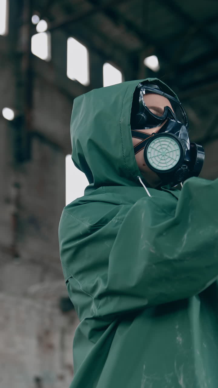 Survivor with flowers in infected zone. Human in protective suit and gas mask holding flowers in abandoned building. Save the nature. Ecological disaster. Vertical video