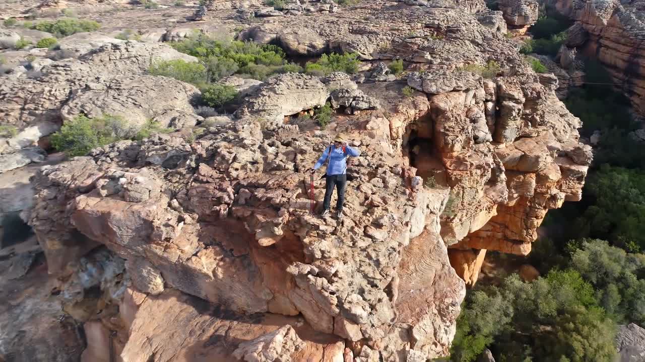 escalador masculino de pie sobre una montaña rocosa 4k