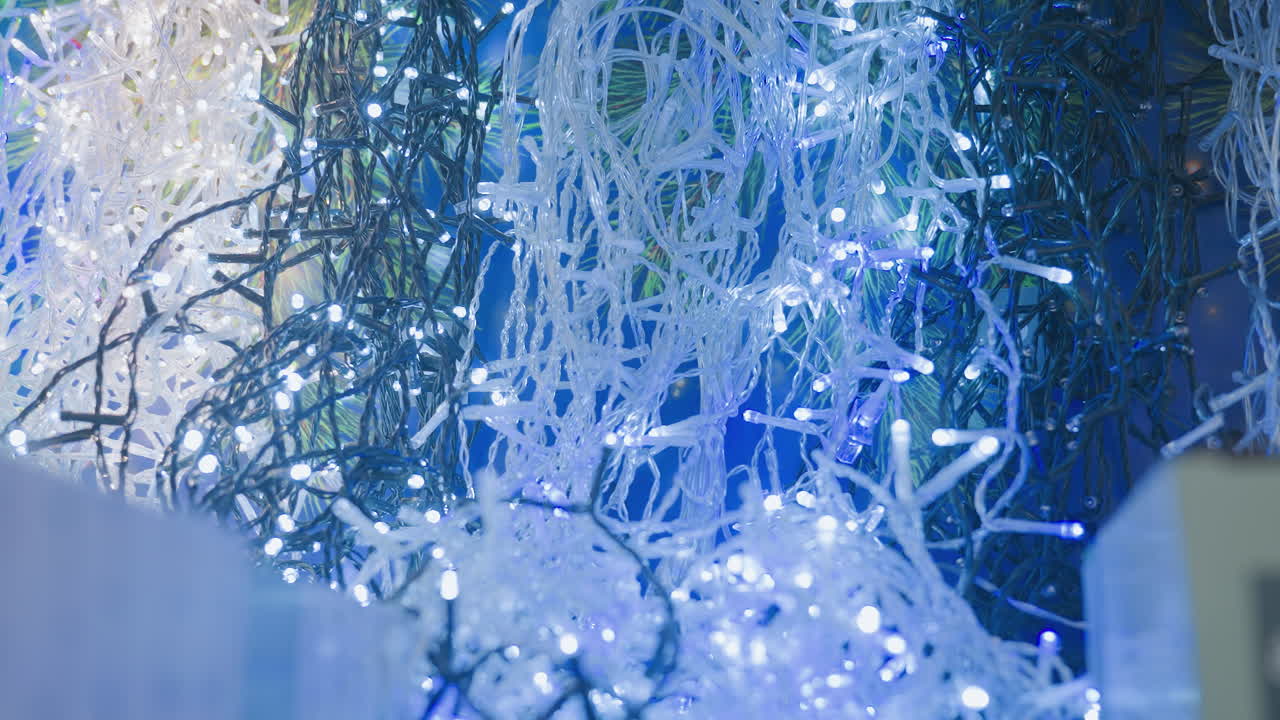 Close-up of beautiful blinking white and multicolored Christmas lights, creating a festive atmosphere, the lights twinkle, enhancing the holiday decor in a vibrant, colorful display