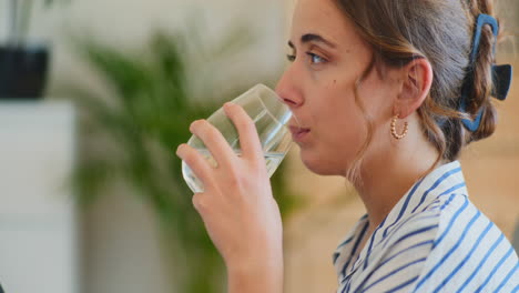 woman drinking water from glass