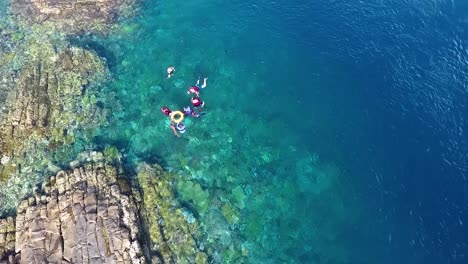 gente buceando en la costa rocosa en el mar tropical en el parque nacional de komodo, vista superior