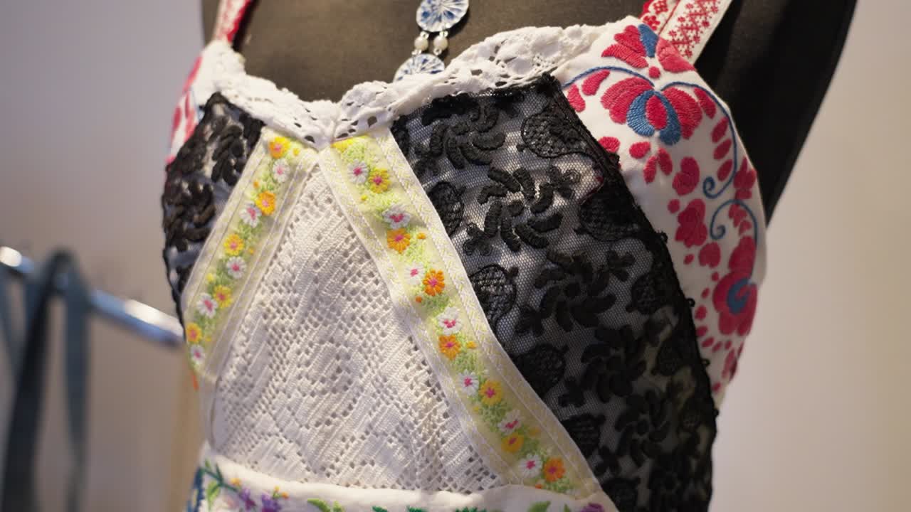 렌즈 와 꽃 패턴 을 가진 봉제 된 빈티지 드레스 의 클로즈업 세부 사항