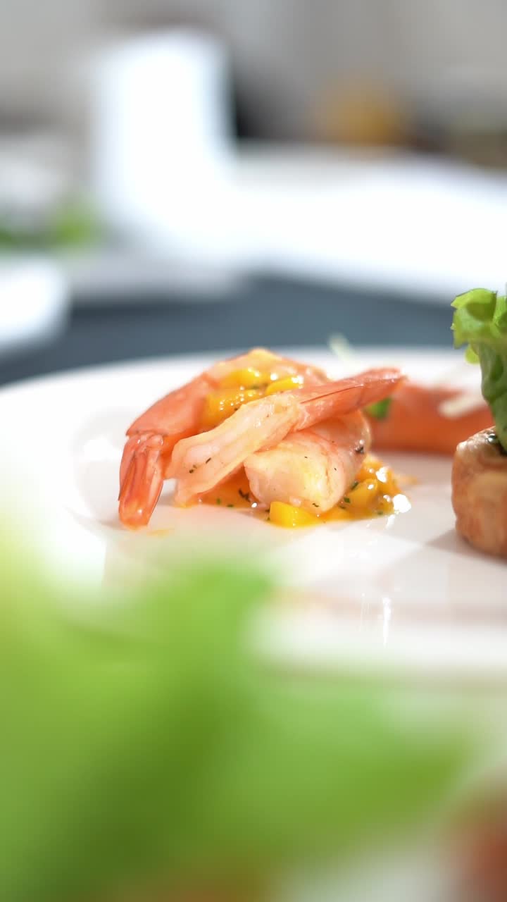 View of plated shrimp dish with colorful peppers, garnished with a yellow sauce, close up shot