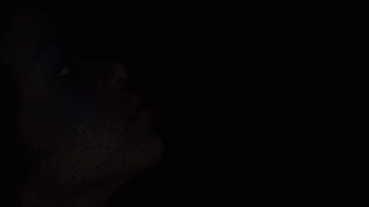 가까운 초상화 아름다운 아프리카계 미국인 여성 이국적인 얼굴 페인트 몸 예술 신비로운 여성 다채로운 메이크업 빛 어두운 배경에서  ⁇ 박이는 창조적 인 표현 개념