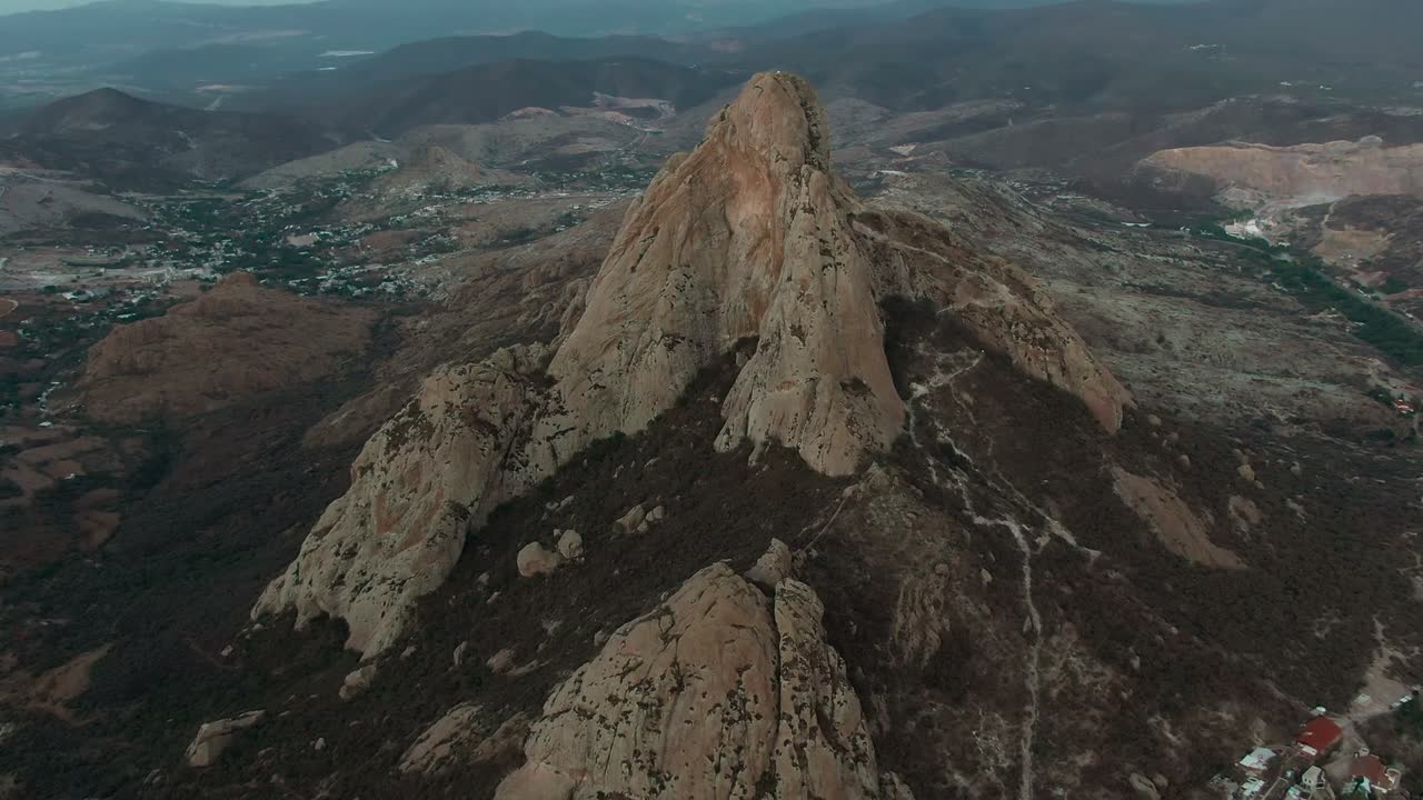 Peña de Bernal, Querétaro, Bajío, Messico - Un imponente monolito di granito si erge drammaticamente dal paesaggio circostante - Ripresa aerea con drone