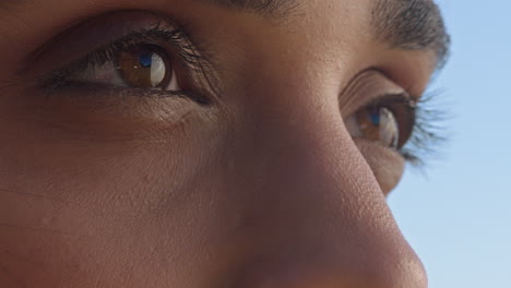 close up of beautiful eyes woman enjoying view relaxing on summer vacation contemplating future looking at sunny outdoors