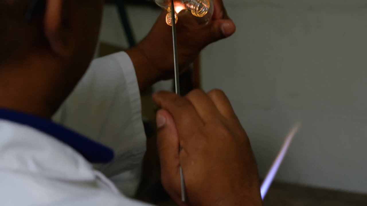 vista trasera de un trabajador masculino creando vidrio en una fábrica de vidrio 4k