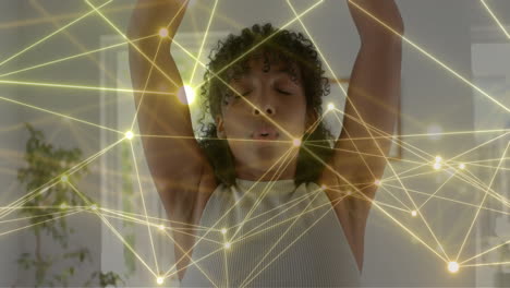 Animation-of-glowing-network-over-biracial-teenage-girl-practicing-yoga-meditation