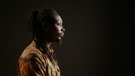 joyful male model posing on camera over black background
