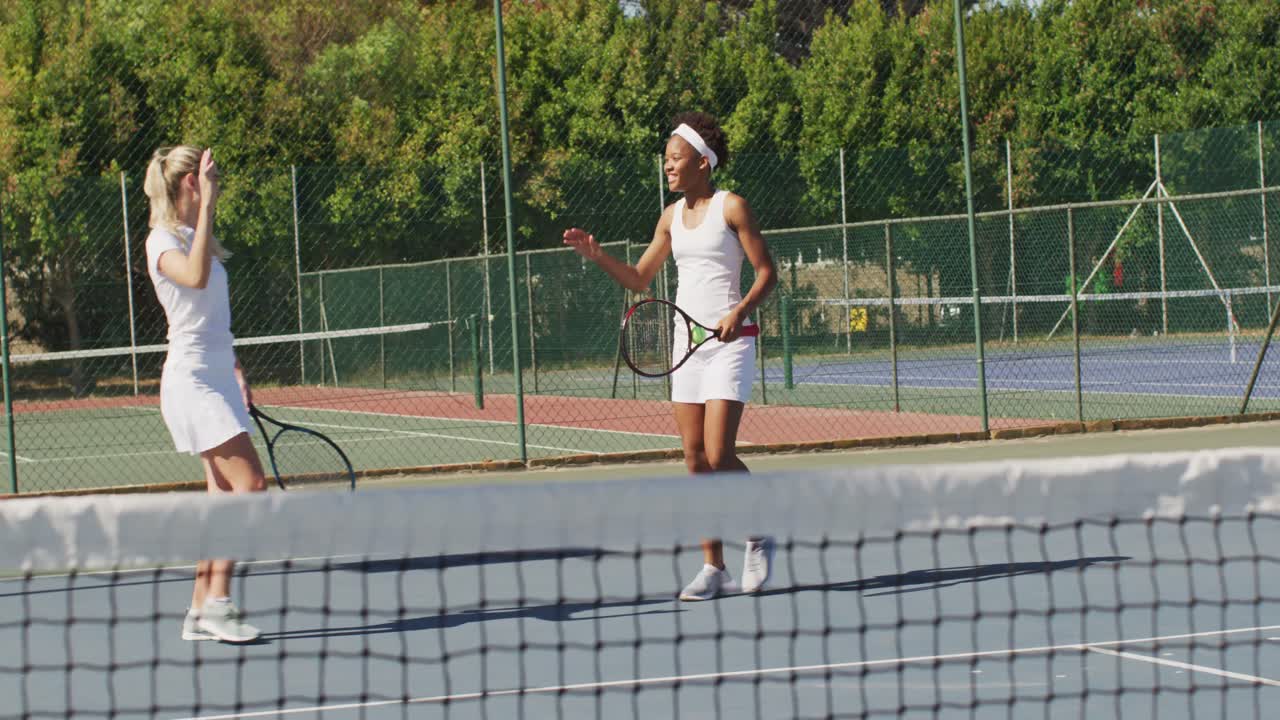 행복 한 다양한 여성 테니스 선수 들 이 라켓 을 들고 손 을 박는 영상