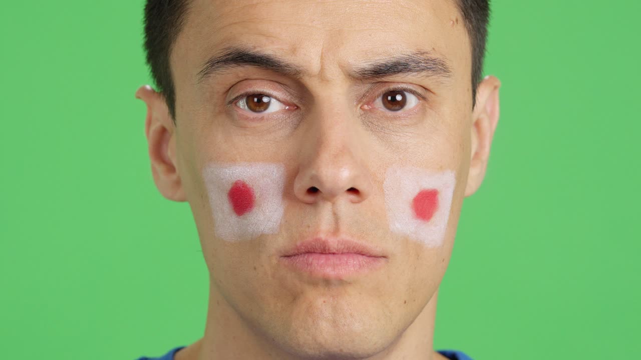 Man with a japanese flag painted on the face smiling