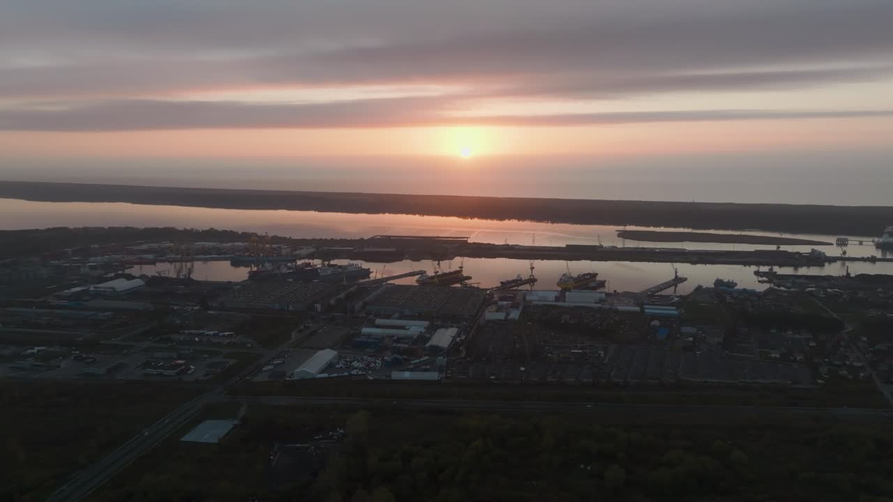 aearila가 항구 인프라와 생산 건물이 있는 산업 도시 지구를 내다보면서 고요한 가을 저녁에 해가 지고 있습니다.