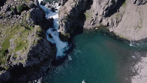 Drohnenaufnahme,-Die-Sich-Mit-Der-Kamera-Dreht-Und-Langsam-über-Den-Wasserfall-Und-Die-Berge-In-Island-4k-Kippt