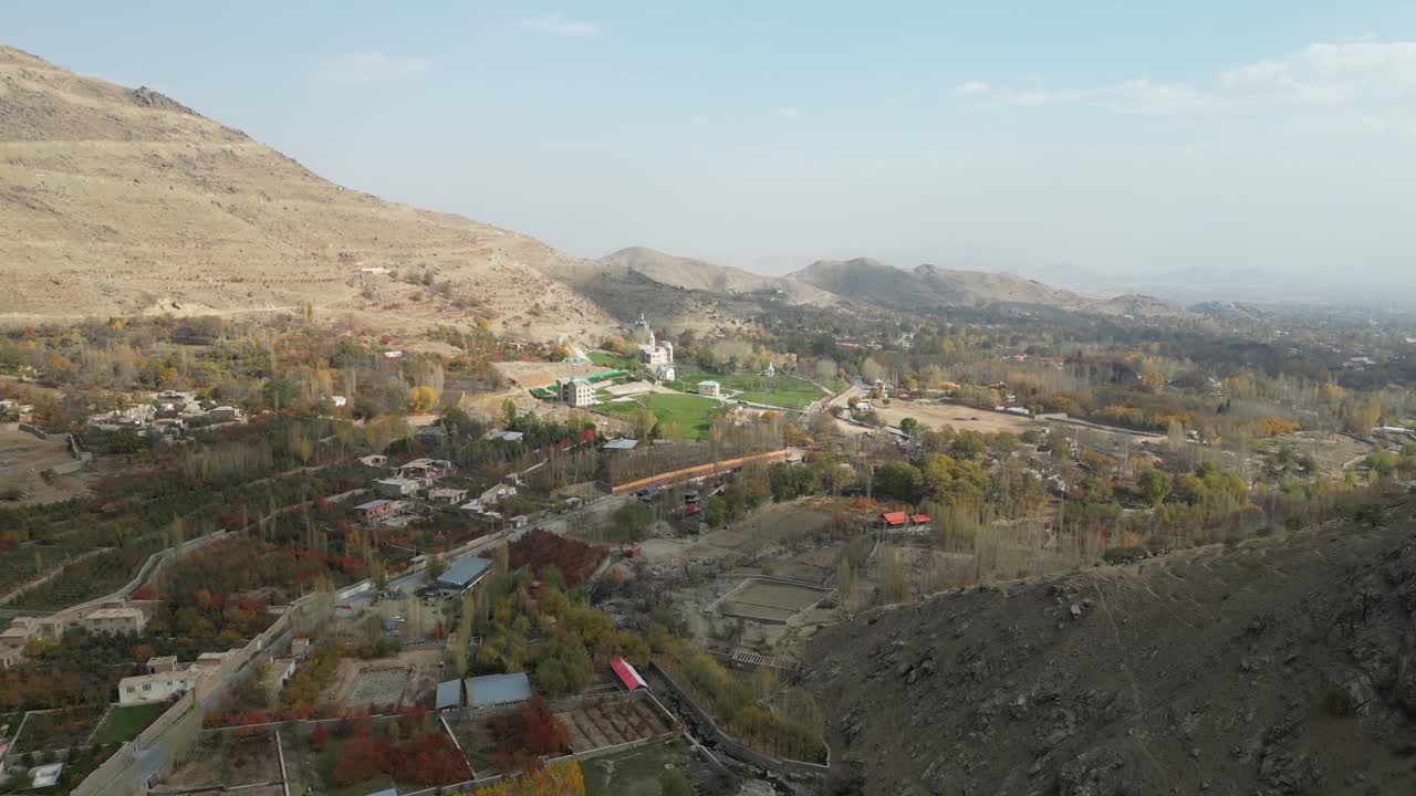 Paghman, Afghanistan, Drone Shot of Town Suburbs, Buildings and Streets Under Hills