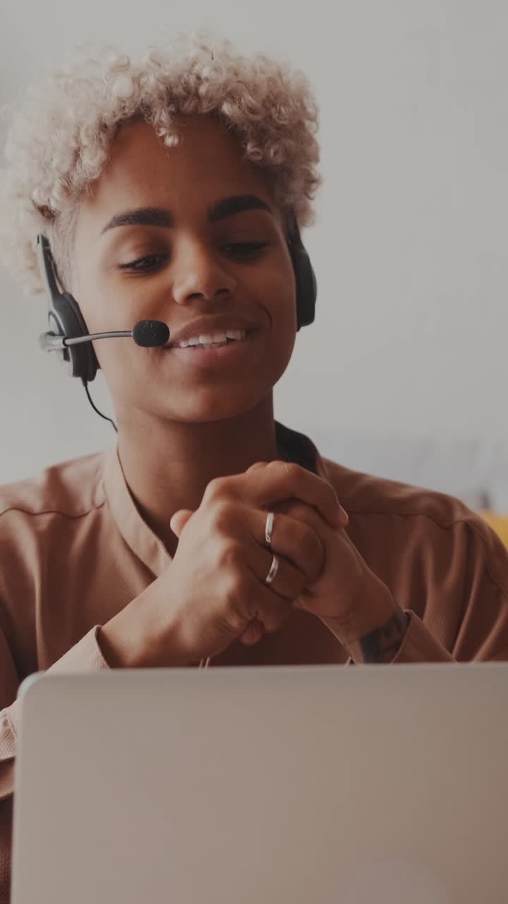 Giovane donna afroamericana seria, specialista del servizio clienti al lavoro
