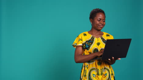 Thoughtful-woman-browsing-websites-on-a-laptop-in-studio