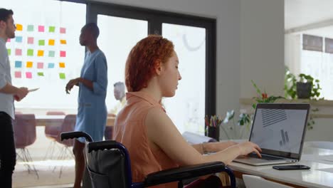 side view of disable young caucasian businesswoman working on laptop in a modern office 4k