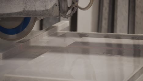 slow motion cabinet maker cutting granite worktop with industrial water cooled table saw.