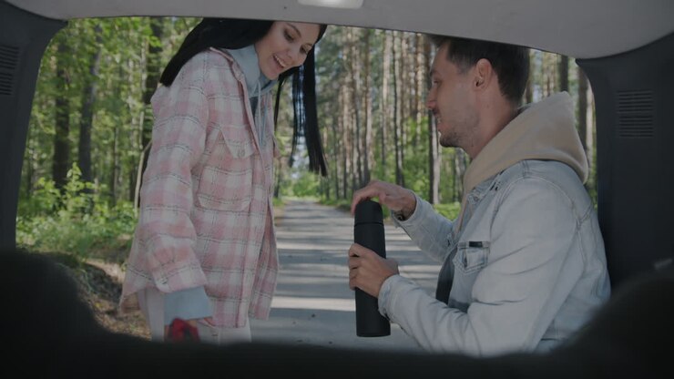 Coppia che si gode un drink durante un viaggio on the road