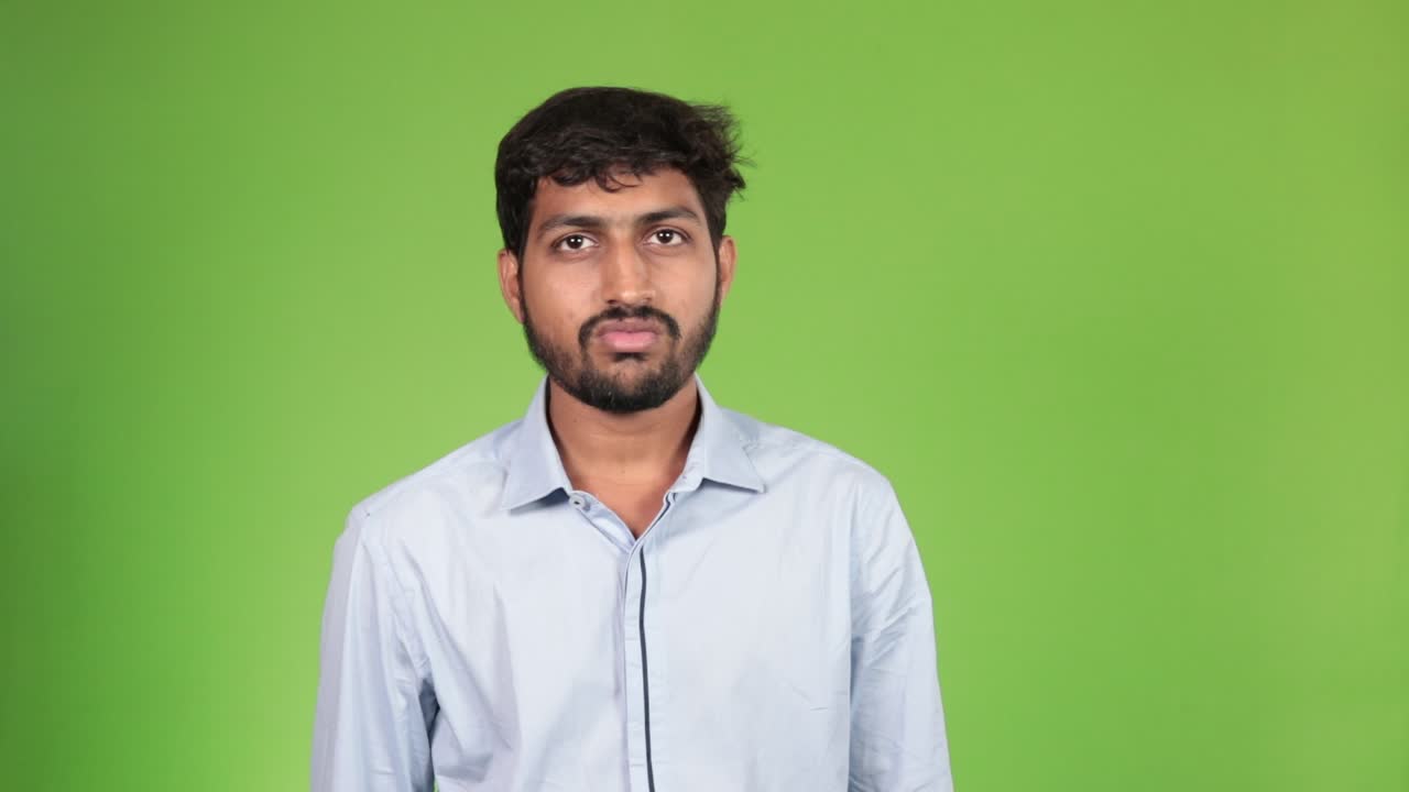 Portrait of a young India man putting on a medical mask against air pollution during covid-19 pandemic on green screen