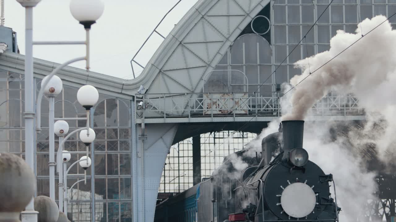 화물 마당을 통과하는 역에 접근하는 증기 기관차 열차