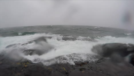 toma en cámara lenta de grandes olas rompiendo en la costa rocosa del lago superior