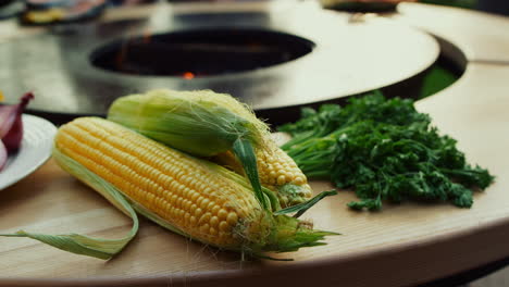 Verduras-Crudas-Colocadas-Cerca-De-La-Parrilla-De-Barbacoa-Al-Aire-Libre.-Maíz-Y-Hierbas-En-El-Patio-Trasero