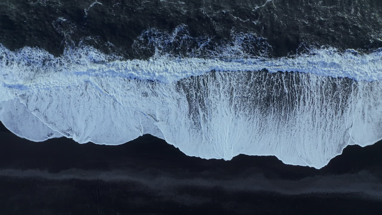olas blancas en la playa de arena negra reynisfjara en islandia