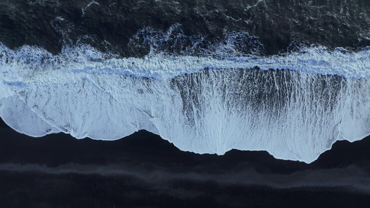 Onde Bianche sulla Spiaggia di Sabbia Nera di Reynisfjara in Islanda