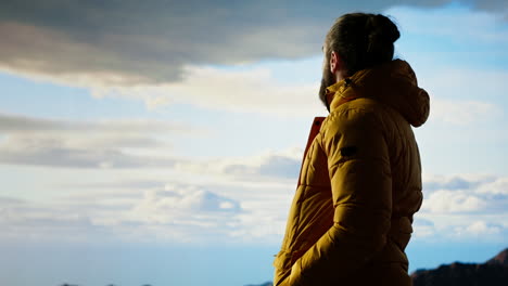 male trekker takes in the breathtaking mountain landscape on rocks