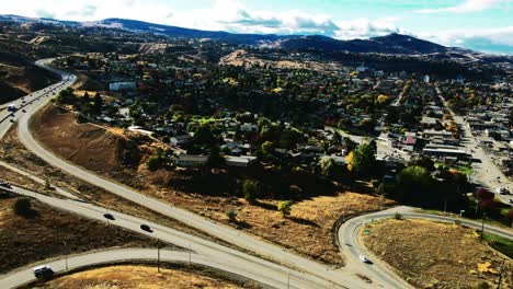 camión derecho drone disparó hiperlapso de kamloops bc canada con puentes y la autopista 1 y la autopista 5 de cabeza amarilla en un día soleado en la ciudad del desierto con automóviles y semirremolques conduciendo en primer plano