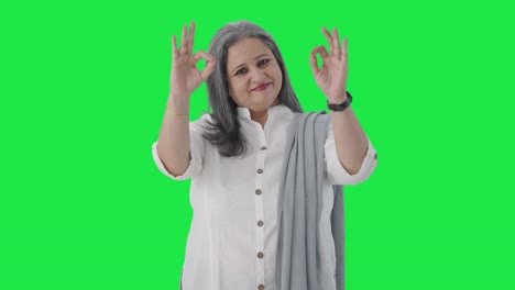 feliz mujer de negocios india senior mostrando bien señal pantalla verde