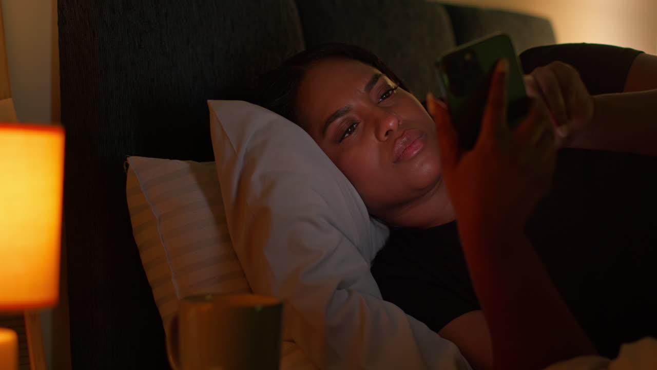 mujer usando el teléfono en la cama por la noche