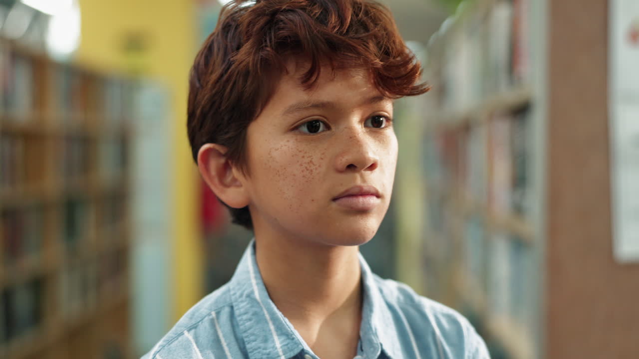Boy reading about dinosaurs in the library