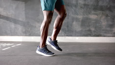 exercising in gym, african american man in athletic shorts and sneakers, focus on legs, copy space