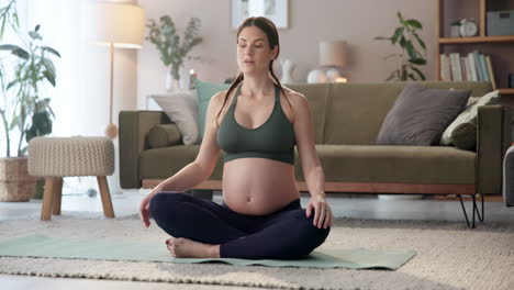 mujer embarazada practicando yoga en casa
